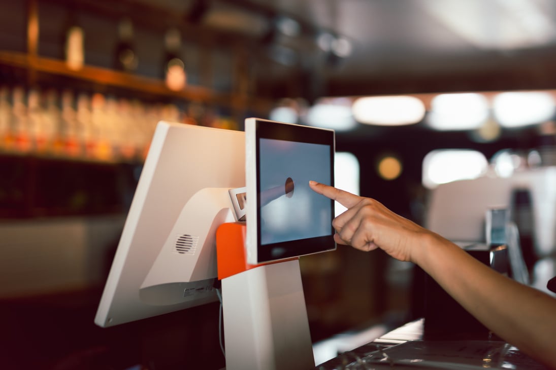 Woman hand doing process payment on a touchscreen cash register.